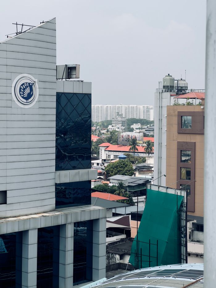 A cityscape view featuring modern architecture and a distant residential area.